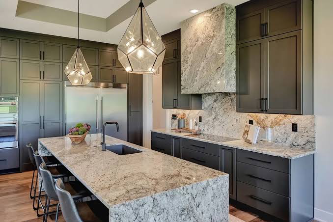 Kitchen with waterfall stone island and slab backsplash by Amici Stone
